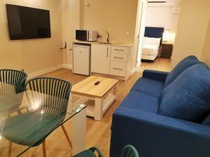 格拉纳达4U Hostel的客厅配有蓝色的沙发和桌子