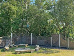 拉科克8 person holiday home in R m的公园里设有长椅和树木围栏