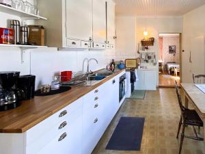 吕克瑟勒Holiday home LYCKSELE的厨房配有白色橱柜和木制台面
