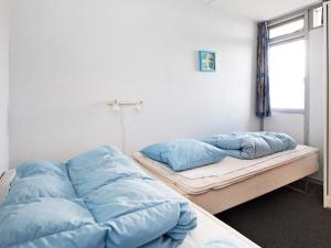 灵克宾6 person holiday home on a holiday park in Ringk bing的配有蓝色枕头的客房内的两张床
