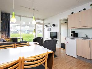 灵克宾6 person holiday home on a holiday park in Ringk bing的厨房以及带桌椅的起居室。