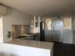 弗里曼特弗里曼特尔港度假屋的白色的厨房配有水槽和冰箱
