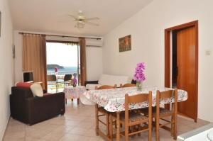 普利兹巴Apartments by the sea Prizba, Korcula - 9276的用餐室以及带桌椅的起居室。