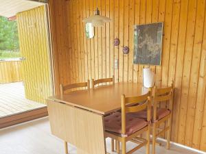 勒兹比5 person holiday home in R dby的一间带木桌和椅子的用餐室