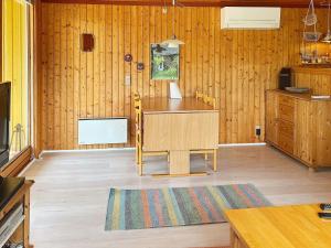 勒兹比5 person holiday home in R dby的厨房设有木墙、桌子和地毯。
