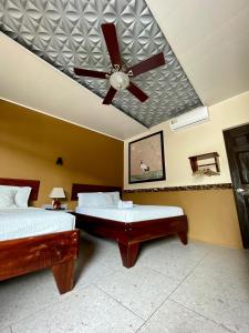 利比里亚Hotel Wilson Condega的一间卧室配有两张床和吊扇