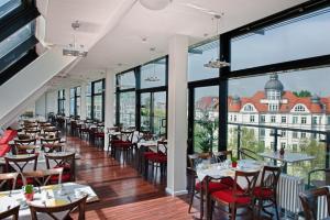 柏林柏林选帝侯大街卡姆酒店的餐厅设有桌椅和大窗户。