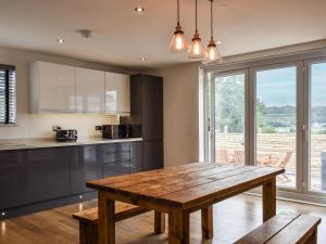 BrynammanHighfield Bungalow的厨房配有木桌和大窗户。
