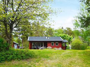 门斯特罗斯Holiday home Mönsterås VII的一座绿树成荫的红房子