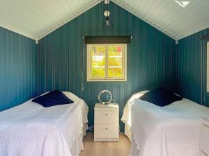 王室港Holiday home KUNGSHAMN XI的绿色的客房设有两张床和窗户。