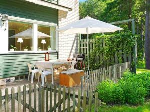 易克略6 person holiday home in EKER的一个带桌子和遮阳伞的庭院