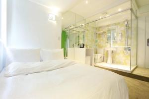 台北复新文旅的卧室配有一张白色大床和淋浴