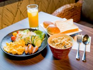 大岛癒楽 伊豆大島的一张桌子,上面放着一盘食物和一杯橙汁