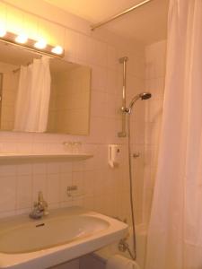 利恩茨利恩茨索恩酒店的浴室配有盥洗盆和带镜子的淋浴