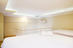 日惹Urbanview Rumah Kandjani Yogyakarta的卧室配有两张白色的床。