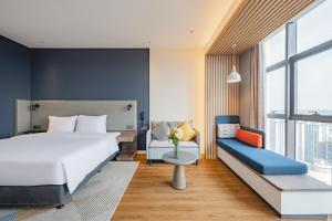 南宁南宁江南智选假日酒店的卧室配有一张白色的大床和一张沙发。