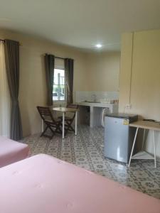 班武里府บ้านในสวนรีสอร์ทBannnaisuan Resort的客房设有一张床、一张桌子和一张桌子。