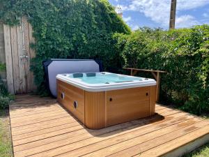 艾格-莫尔特myinsolite - Tiny-house, jacuzzi, brasero, piscine的木甲板上的一个热水浴缸
