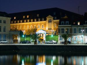 里尔联盟酒店的夜间在河边的一座有照明的建筑