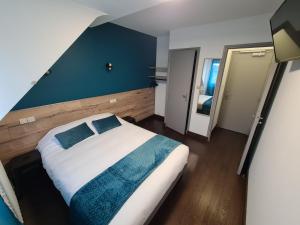 拉沙特尔Berry Hôtel La Châtre的一间卧室设有一张大床和蓝色的墙壁