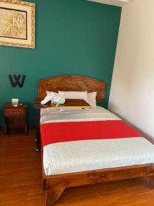 UpalaHotel Wilson Upala的一间卧室配有一张带红白毯子的床