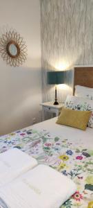 Le Bois de NèflesVILLA GARRIGA的一间卧室配有一张带花卉床罩的床