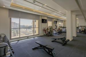 吉达Sunset Jeddah的健身房设有有氧器材和大窗户