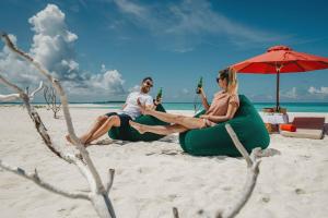 DhigurahSiyam World Maldives - 24-Hour Premium All-inclusive with Free Transfer的坐在海滩上充气的四肢的男人和女人