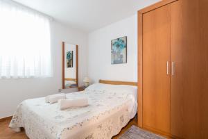 普利拉卡Kristi apartment complex的一间卧室配有一张床和一个大型木制橱柜