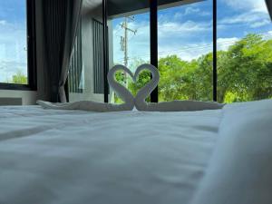 ลานนา รีสอร์ท的床上的白色心灵装饰,设有窗户