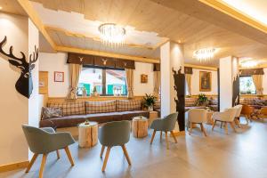 莫埃纳Monza Dolomites Hotel的大堂配有沙发和桌椅