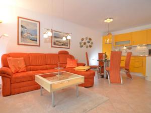 奥斯赛拜-塞林Strandwohnungen Sellin - WG02 mit Terrasse的一间带橙色沙发的客厅和一间厨房