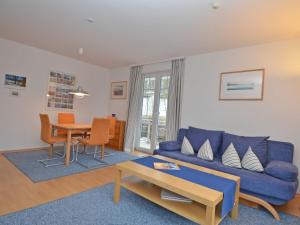 奥斯赛拜-塞林Strandwohnungen Sellin - WG04 mit 2 Balkonen的客厅配有蓝色的沙发和桌子