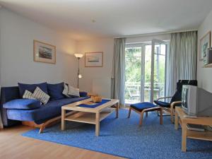 奥斯赛拜-塞林Strandwohnungen Sellin - WG04 mit 2 Balkonen的客厅配有蓝色的沙发和电视