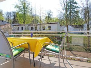 奥斯赛拜-塞林Strandwohnungen Sellin - WG04 mit 2 Balkonen的阳台的黄色桌子和椅子