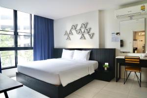 曼谷曼谷130号酒店及公寓的一间卧室配有一张大床、一张书桌和一个窗户。
