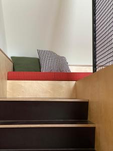 马里博尔Isabella Living的一张平台床,上面有红色和绿色的枕头