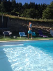 Saint-AppolinaireLe domaine des Terres的一位女士在游泳池旁行走
