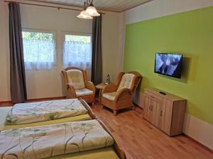 ClenzeLandhotel Sonnenhof im Wendland的一间卧室配有两张床和椅子以及电视