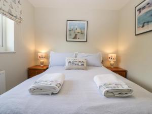 布里德波特The Beach House的卧室配有白色床和毛巾