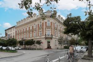 克拉科夫Perła Starego Miasta Kamienica Czapskich by Renters的一名妇女在建筑物前骑着自行车