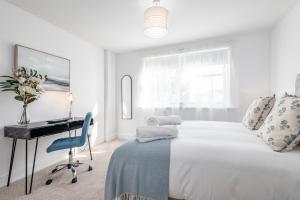 圣安德鲁斯Skye Sands - City Road Residence - Central St Andrews的白色卧室配有书桌和床