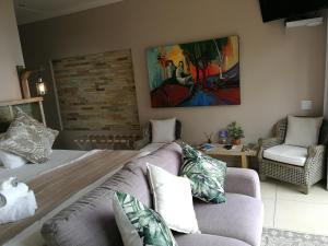 莫塞尔湾Lavandula Manor Self-Catering的客厅配有沙发和墙上的绘画