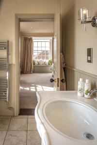 朗梅尔福德The Black Lion, Long Melford的一间带白色水槽的浴室和一间客厅