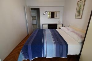 希洛App2 Marin的一间卧室配有一张带蓝白色毯子的床
