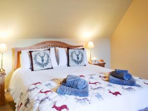 UrrayGlebe Cottage的一间卧室配有一张带蓝色毛巾的床