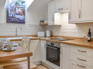 EynsfordThe Stables At Early Autumn的厨房配有白色橱柜、桌子和水槽。