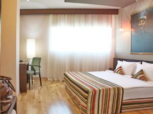 贝尔格莱德Design Hotel Mr President的一间卧室设有一张大床和一个窗户。
