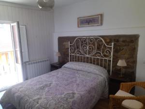 安普埃罗Fuentinueva的一间卧室配有一张带紫色棉被的床