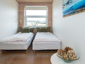 凡岛Holiday home Fanø CLXXVIII的配有桌子和窗户的客房内的两张床